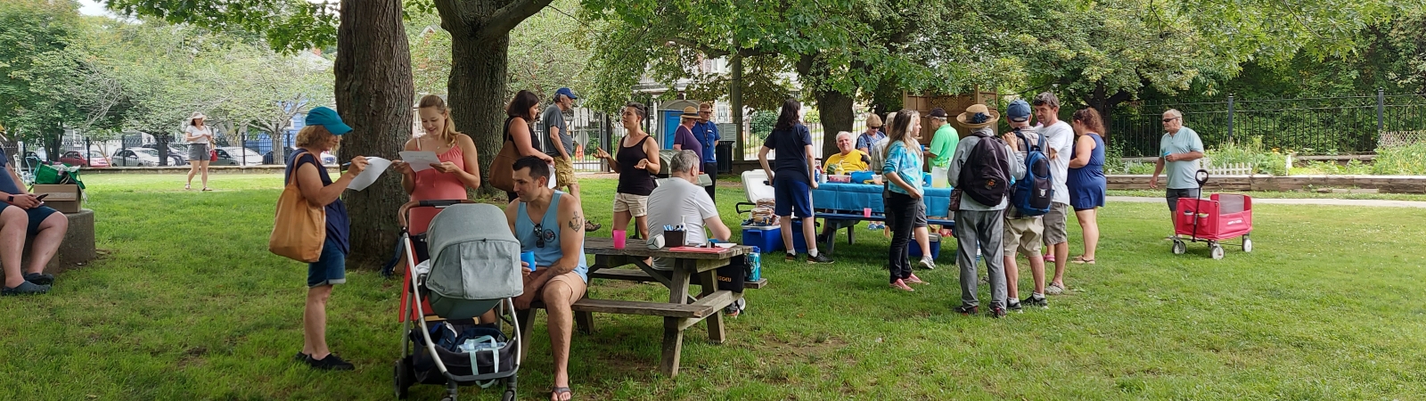 a group of eac supporters gathered around picnic tables in a park