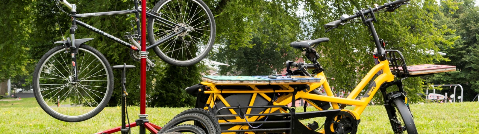 a yellow bike next to a bike on a repair stand