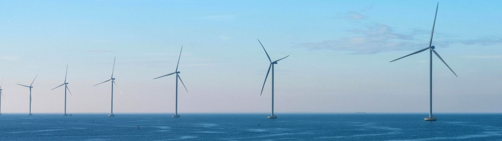 image of seven offshore wind turbines under a pink and blue sky
