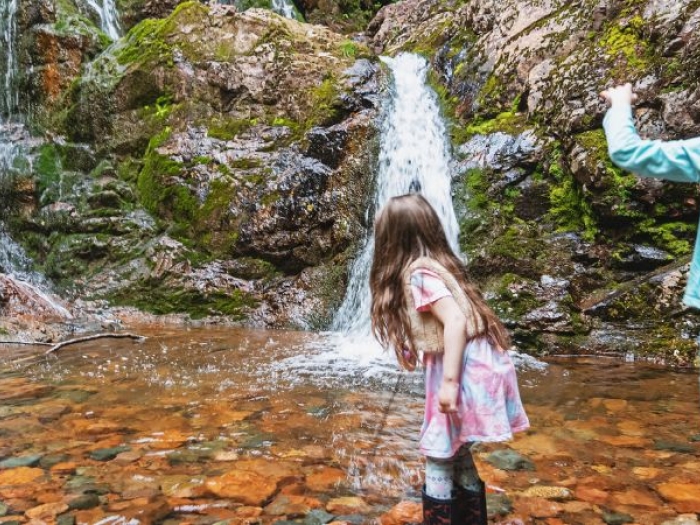 two kids playing by a small waterfall