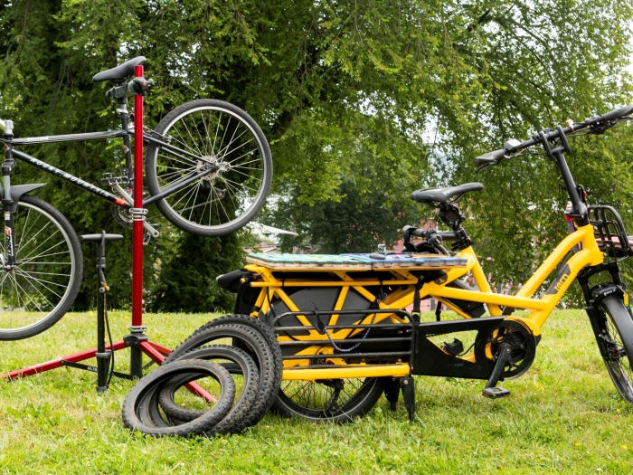 a yellow bike next to a bike on a repair stand