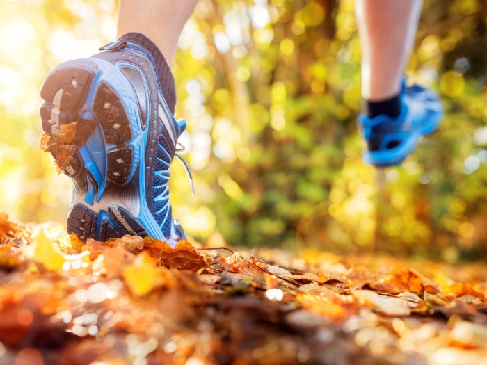 a person running over fall leaves