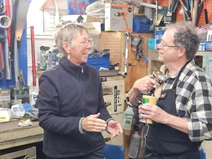 three senior adults volunteering in the bike shed