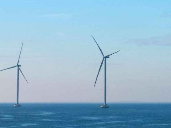 image of seven offshore wind turbines under a pink and blue sky
