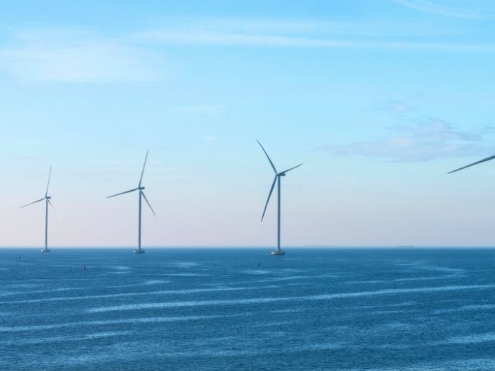 Image of an offshore wind farm against a clear blue sky